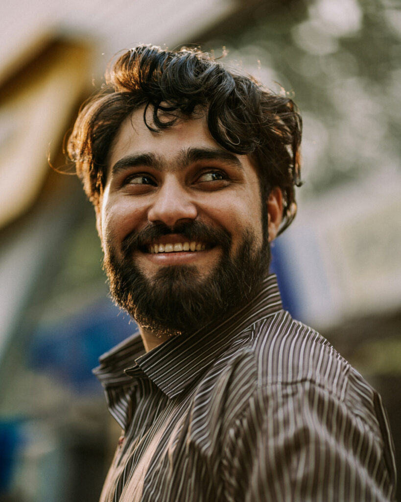 A smiling man, looking over his shoulder.